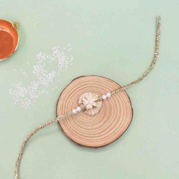 Some bonds last a lifetime. And when it comes to sibling love, even a lifetime of affection is not enough. This Rakhi, celebrate your extraordinary relationship with handcrafted Rakhis. The flowers adds to its elegance and makes it perfect for your sibling. Designed with pearls,gota and flowers - this rakhi is one of a kind Includes 1 SRose Gold Gota Single Flower Chakalya Rakhi